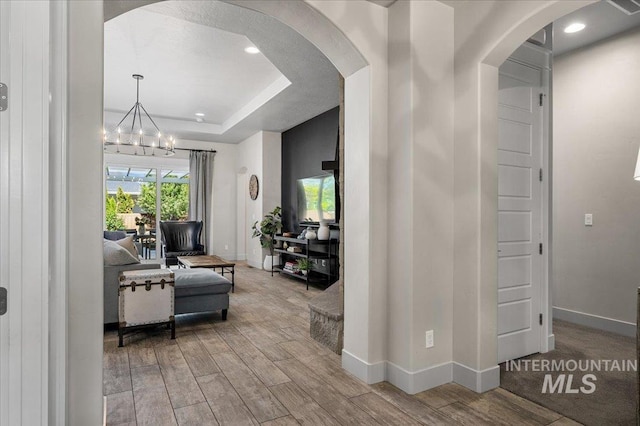 2357 N Synergy Pl, Eagle, ID 83616 - hallway featuring arched walkways, baseboards, a chandelier, wood finished floors, and recessed lighting