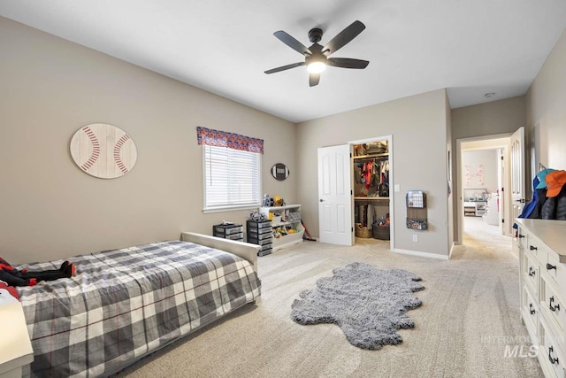 carpeted bedroom with a spacious closet, a closet, and ceiling fan