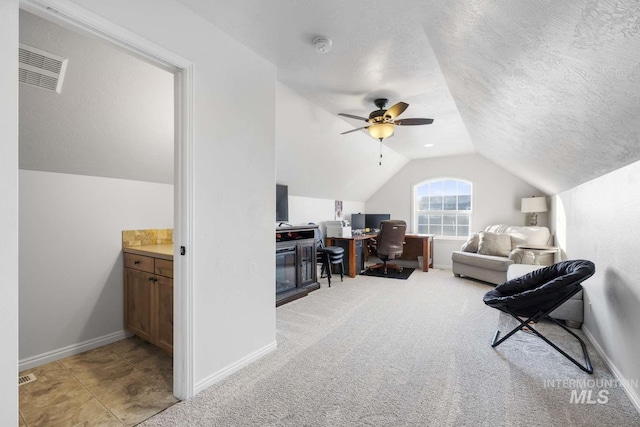 interior space featuring ceiling fan, a textured ceiling, lofted ceiling, and carpet floors