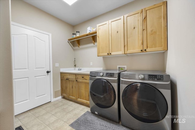 laundry room with sink, washer and dryer, and cabinets