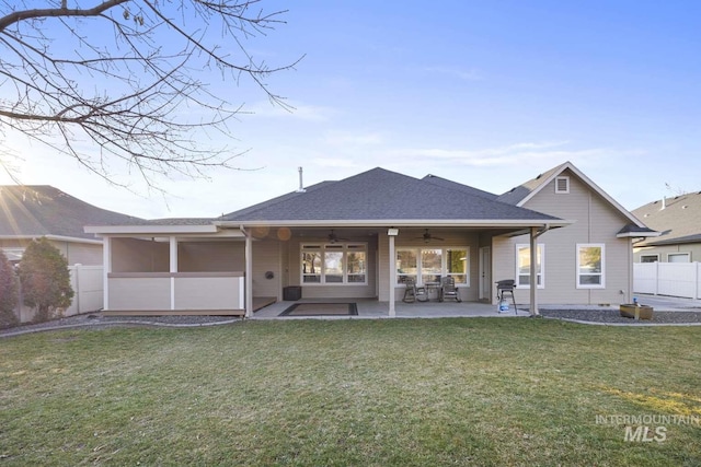 back of house featuring a sunroom, ceiling fan, a patio area, and a yard