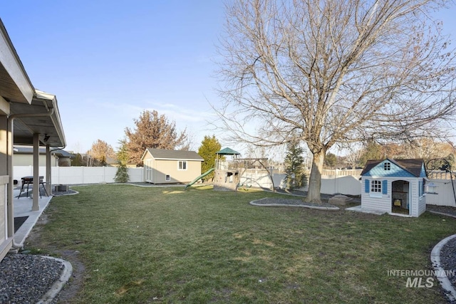 view of yard with a storage shed and a playground