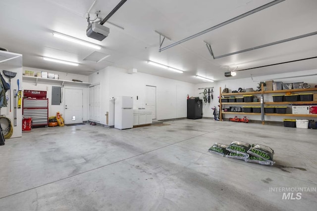 garage with a garage door opener, electric panel, black fridge, and white refrigerator