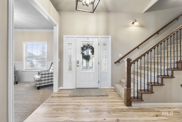 foyer entrance with wood-type flooring and ornamental molding