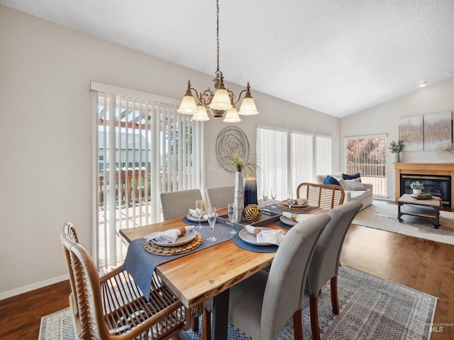 1415 E Lake Crk, Meridian, ID 83642 - dining room with a chandelier, wood finished floors, lofted ceiling, baseboards, and a glass covered fireplace
