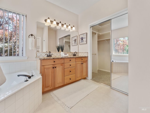 1415 E Lake Crk, Meridian, ID 83642 - bathroom featuring double vanity, a bath, a walk in closet, and tasteful backsplash