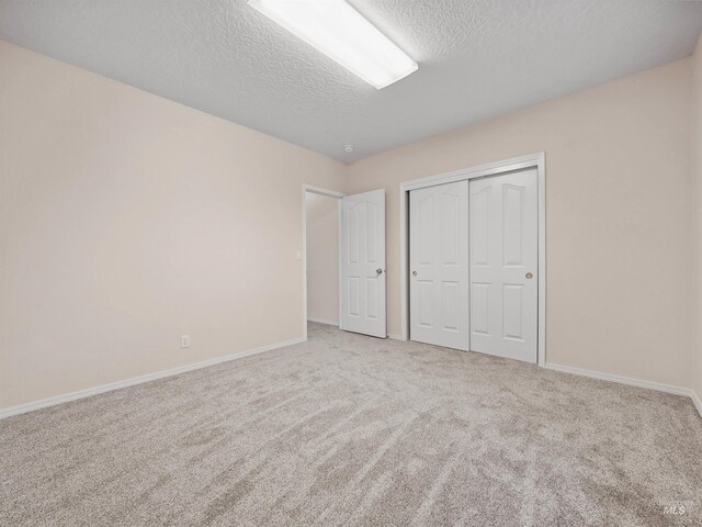 1415 E Lake Crk, Meridian, ID 83642 - unfurnished bedroom with a textured ceiling, carpet floors, a closet, and baseboards
