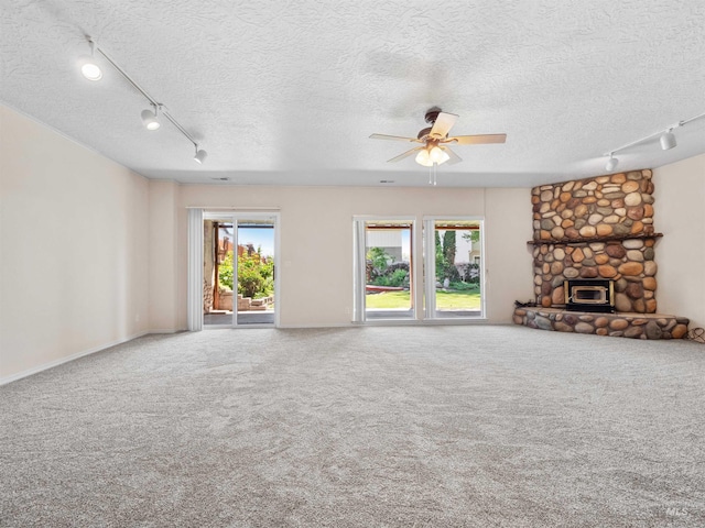 1415 E Lake Crk, Meridian, ID 83642 - unfurnished living room with track lighting, a textured ceiling, a ceiling fan, carpet flooring, and a fireplace