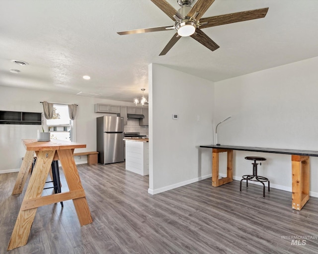 504 E 7th St, Emmett, ID 83617 - unfurnished dining area with baseboards, wood finished floors, ceiling fan, a chandelier, and recessed lighting