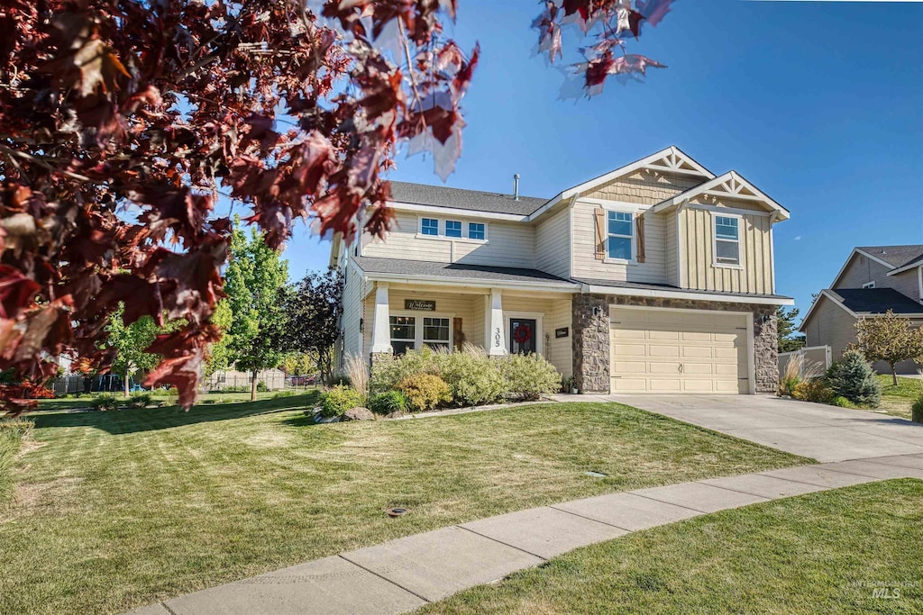 craftsman house with a front lawn and a garage