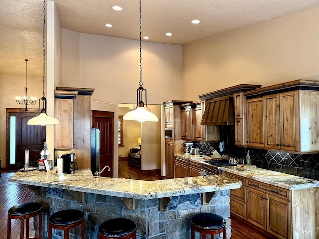 20 Shore Crest Ct, Donnelly, ID 83615 - kitchen with a towering ceiling, dark wood-style flooring, a breakfast bar area, tasteful backsplash, and high end stainless steel range