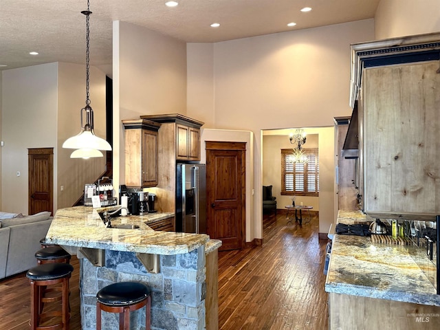 20 Shore Crest Ct, Donnelly, ID 83615 - kitchen featuring stainless steel refrigerator with ice dispenser, a sink, dark wood-style flooring, a breakfast bar, and a high ceiling