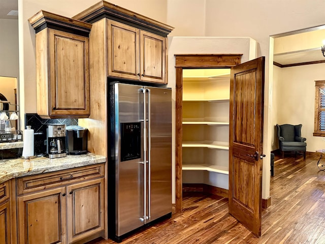 20 Shore Crest Ct, Donnelly, ID 83615 - kitchen featuring stainless steel fridge, dark wood finished floors, light stone counters, decorative backsplash, and crown molding