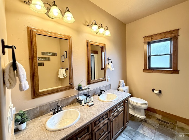 20 Shore Crest Ct, Donnelly, ID 83615 - bathroom with toilet, double vanity, baseboards, and stone finish flooring