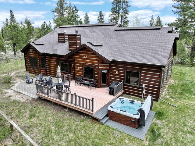 20 Shore Crest Ct, Donnelly, ID 83615 - rear view of house with a hot tub, a wooden deck, roof with shingles, outdoor dining area, and a chimney