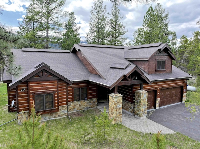 20 Shore Crest Ct, Donnelly, ID 83615 - log home with stone siding, an attached garage, a shingled roof, asphalt driveway, and a front lawn