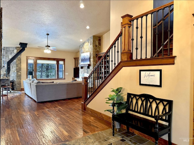 20 Shore Crest Ct, Donnelly, ID 83615 - living room with a wood stove, a textured ceiling, stairway, ceiling fan, and hardwood / wood-style floors
