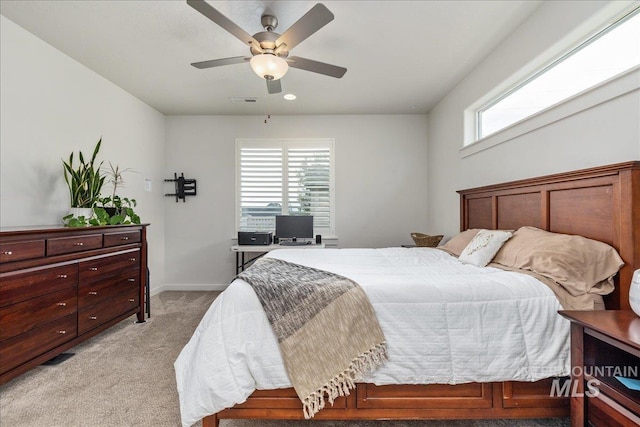bedroom with light colored carpet, baseboards, and a ceiling fan