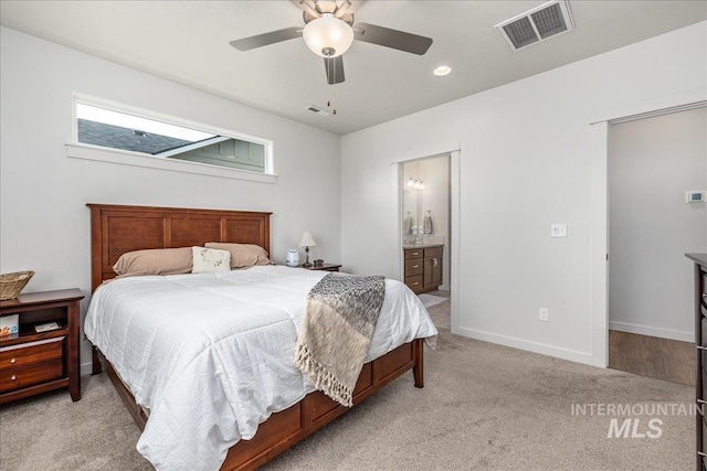 bedroom featuring light colored carpet, baseboards, ensuite bath, and ceiling fan