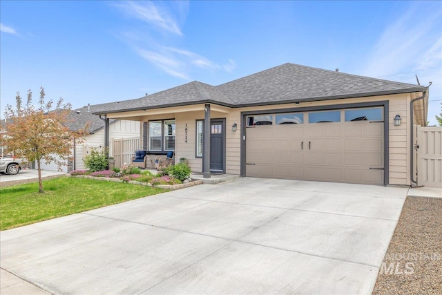 ranch-style house with a porch, concrete driveway, a garage, and roof with shingles
