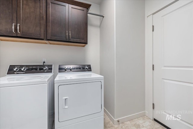 clothes washing area featuring cabinet space, independent washer and dryer, and baseboards