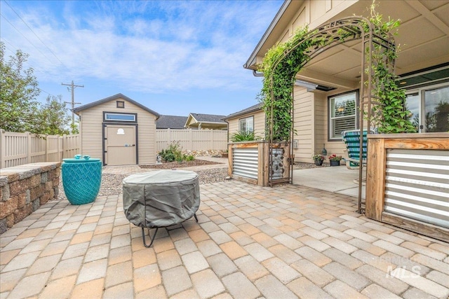 view of patio featuring a storage shed, an outdoor structure, and a fenced backyard
