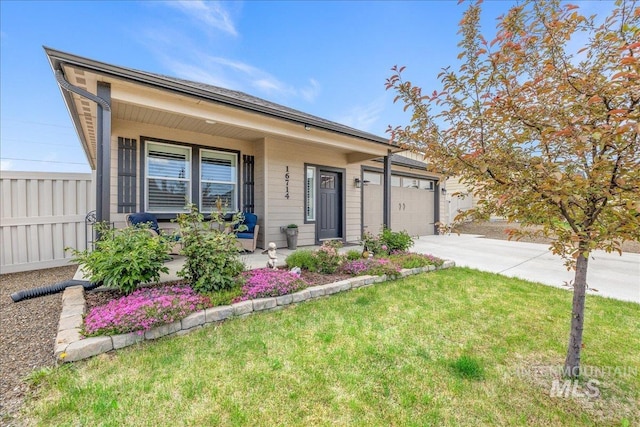 ranch-style home featuring concrete driveway, covered porch, a garage, and a front lawn