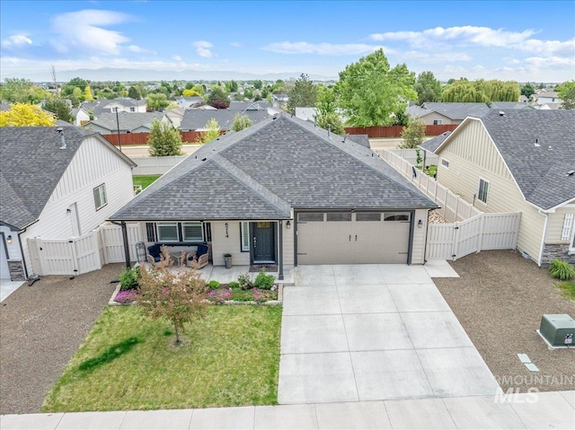 view of front of property with a gate, roof with shingles, a garage, concrete driveway, and a residential view