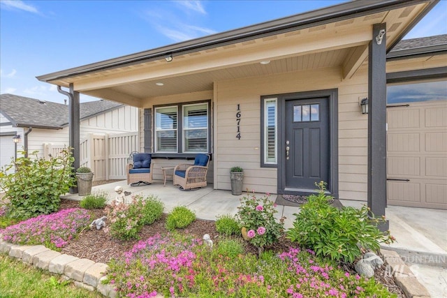entrance to property with a porch and fence