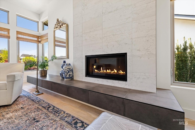living area featuring a tiled fireplace and wood finished floors