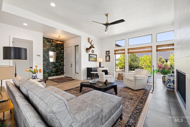 living room with plenty of natural light, recessed lighting, ceiling fan, and a tiled fireplace