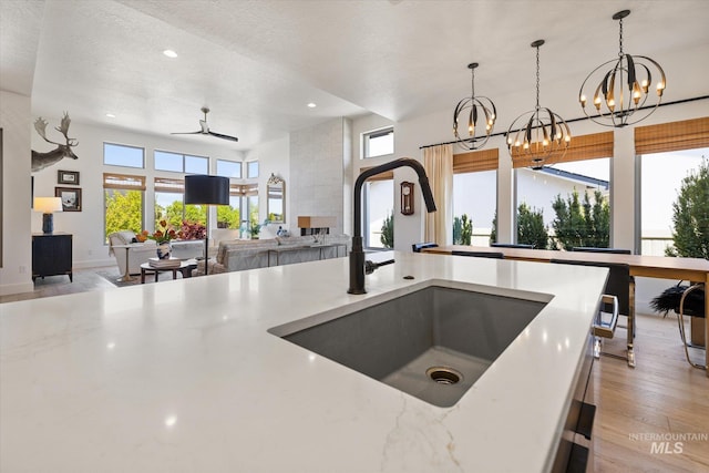 kitchen featuring recessed lighting, a healthy amount of sunlight, a sink, and ceiling fan with notable chandelier