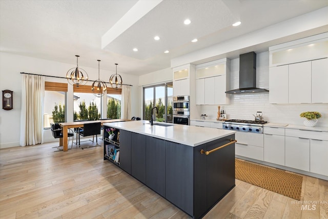 kitchen featuring white cabinetry, modern cabinets, wall chimney range hood, and stainless steel appliances
