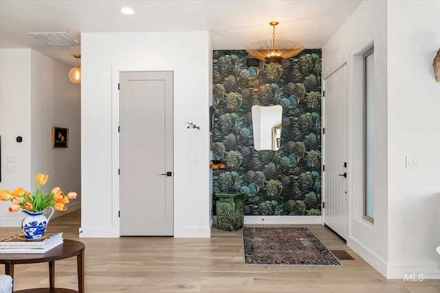 entryway with baseboards, wood finished floors, and visible vents