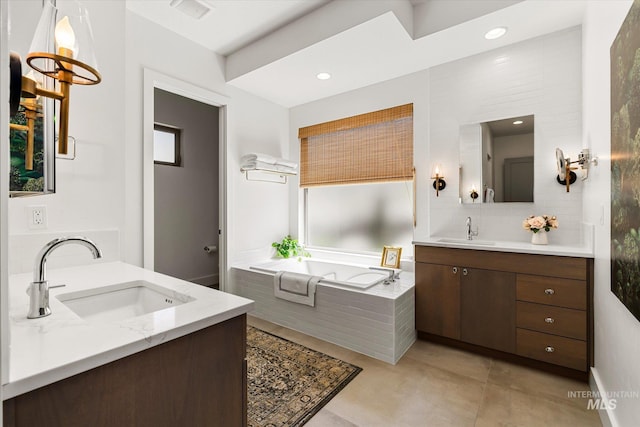 full bath featuring a sink, two vanities, a bath, and visible vents
