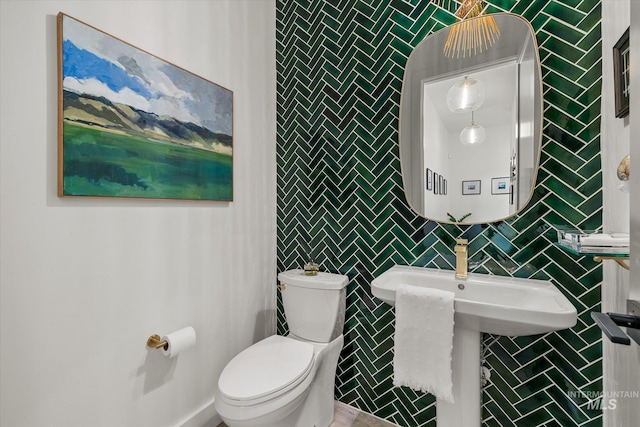 bathroom featuring tile walls and toilet