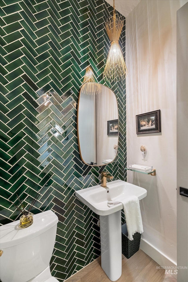 bathroom with toilet and tile walls
