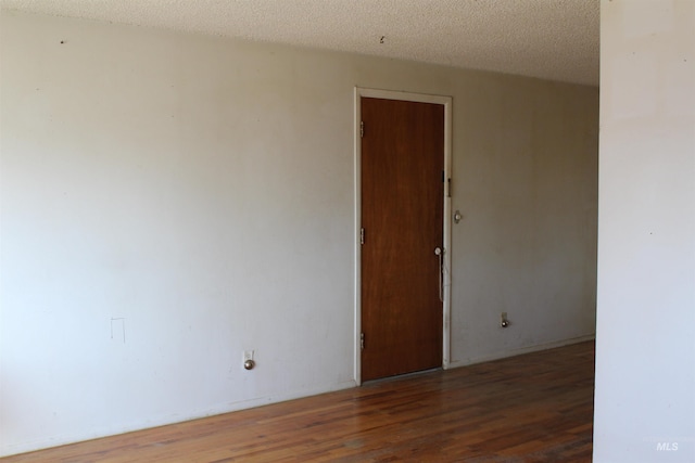 spare room with hardwood / wood-style flooring and a textured ceiling