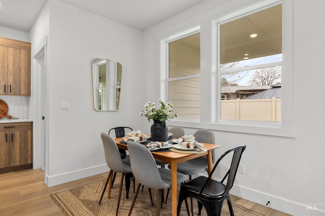 dining space with baseboards and light wood-style floors