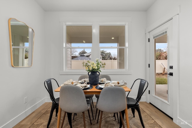 dining room with baseboards and light wood finished floors