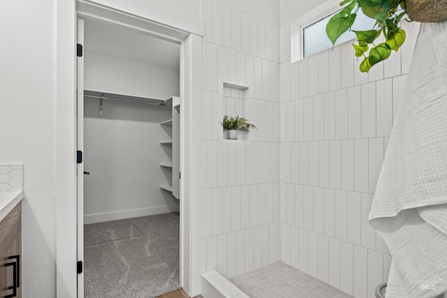 bathroom featuring baseboards and a tile shower