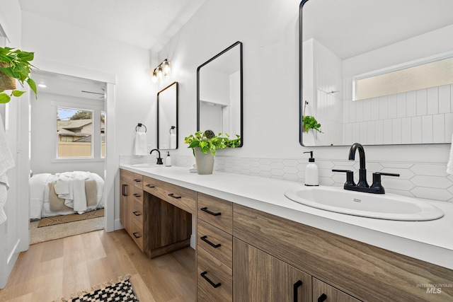 bathroom featuring wood finished floors, a sink, and a wealth of natural light