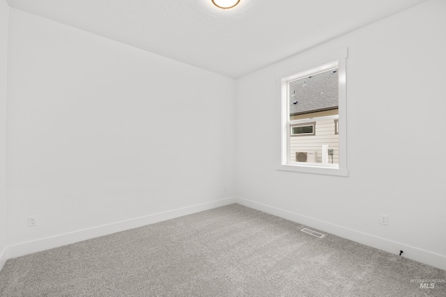 unfurnished room featuring carpet flooring, visible vents, and baseboards