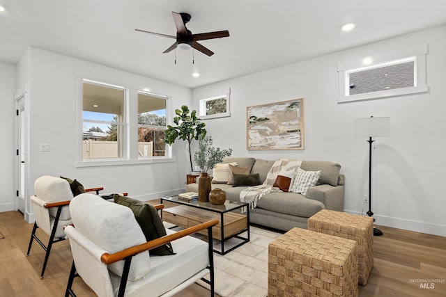 living area with a ceiling fan, baseboards, and light wood finished floors