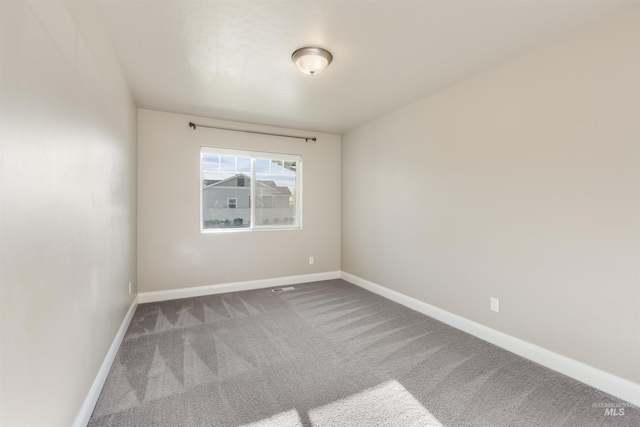 unfurnished room featuring carpet floors and baseboards