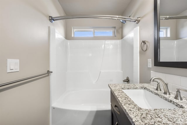 full bath with healthy amount of natural light, vanity, and bathtub / shower combination