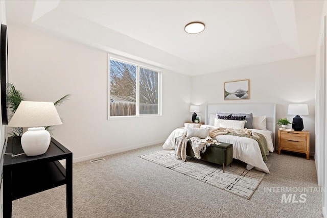 bedroom featuring visible vents, carpet, a raised ceiling, and baseboards