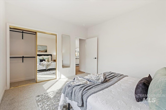 bedroom with a closet, carpet flooring, and baseboards