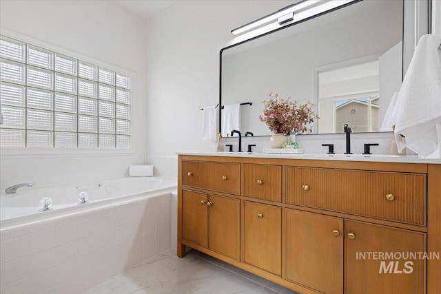 full bathroom featuring double vanity, a bath, marble finish floor, and a sink