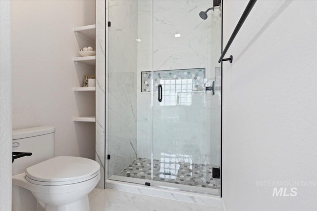 full bathroom featuring toilet, marble finish floor, and a marble finish shower